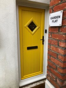 StormMeister® uPVC Inward Opening Flood Door, colour - yellow, Panel - Bullion, CD style glazing (6.8 laminate glass externally and 4 mm toughened glass internally), black Handle - black letter box - fitted with the StormMeister® active flood seal.
