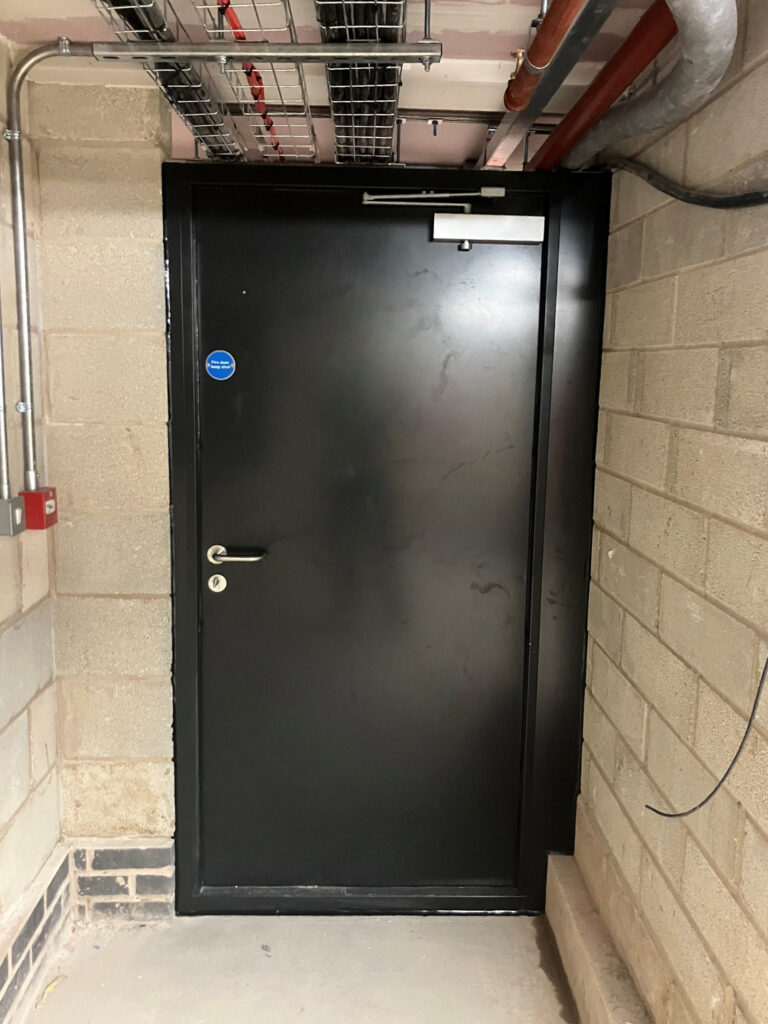 Flood Protection Steel Door with satin black paint finish. lever handle with a thumb turn.