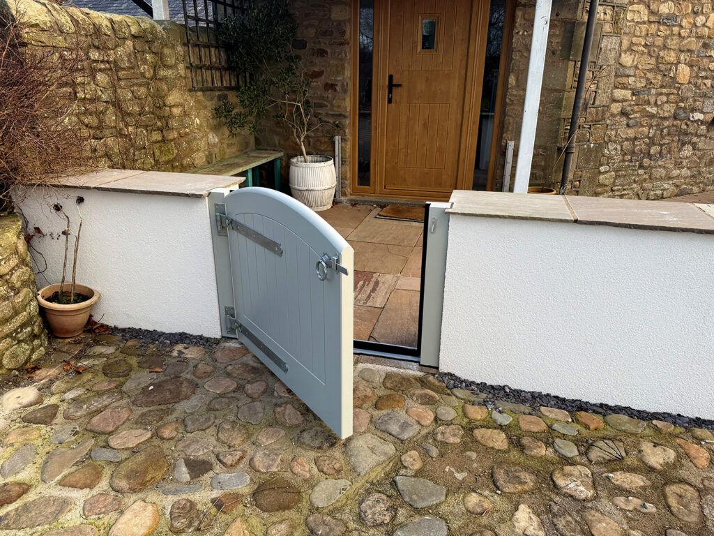 Open Flood Gate Showing the Flood seal, Accoya timber, Colour Finished in Light Grey. Fitted with Silver ironmongery at a residential Property.